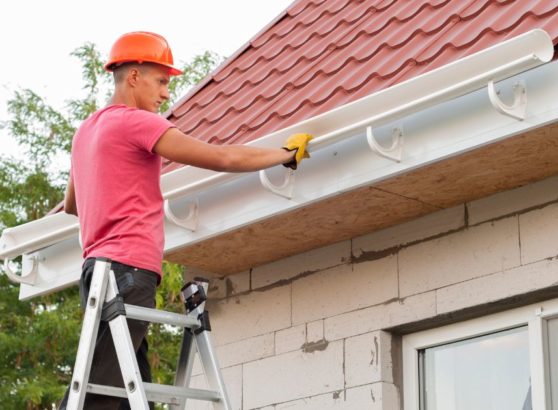 Worker installing gutter system