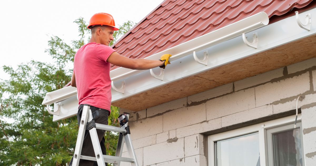 Worker installing gutter system