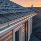 Modern residential roof with dark asphalt shingles, durable gutter system, and leaf guard