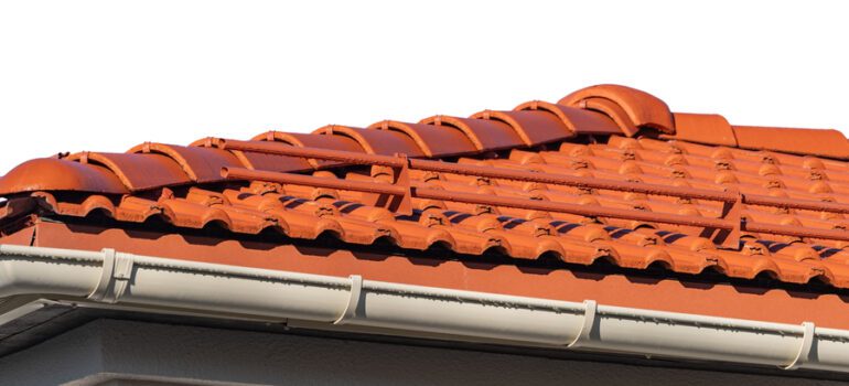 a roof with red tiles and white gutters ready for leaf guard installation